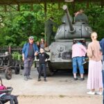 Grupa ludzi wśród eksponatu - czołgu T-34.